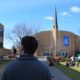 The associate dean of men walking past Kretschmar Hall toward the University Church at Walla Walla University