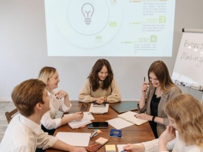 A bunch of business major students around a table discussing business.