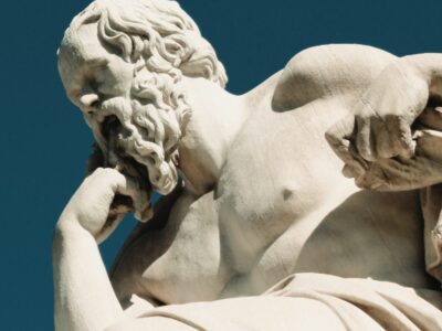 A greek statue pondering with blue sky behind him